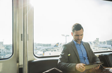 Germany, Frankfurt, young businessman in bus at the airport - UUF003461