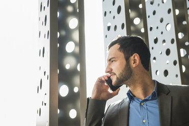 Junger Geschäftsmann am Mobiltelefon - UU003432