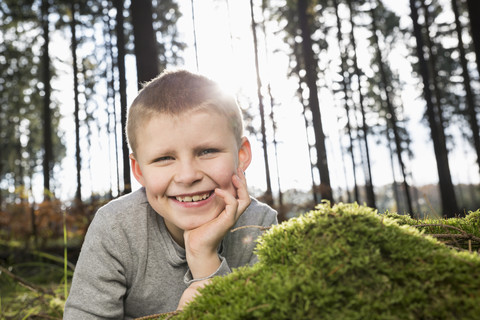 Deutschland, Porträt eines lächelnden kleinen Jungen in einem Wald, lizenzfreies Stockfoto