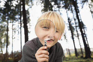 Little boy looking through magnifying glass at viewer - PDF000817