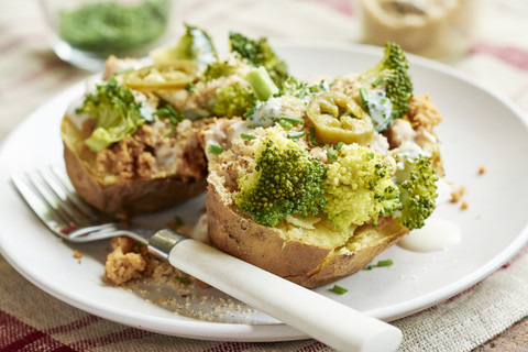 Baked potato with broccoli, soy yogurt and vegan parmesan cheese stock photo