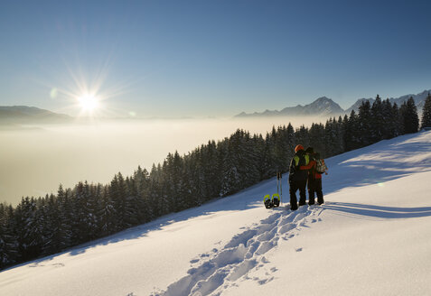 Österreich, Tirol, Schwaz, Paar mit Schneeschuhen mit Blick auf die Aussicht - MKFF000171