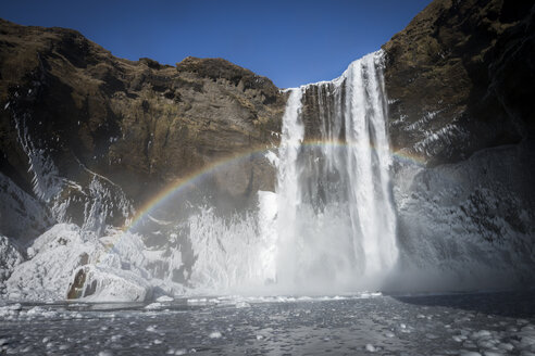 Island, Skogafoss Wasserfall im Winter, Regenbogen - STCF000070