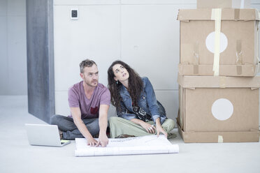 Creative office people sitting with a construction plan and boxes - ZEF003011