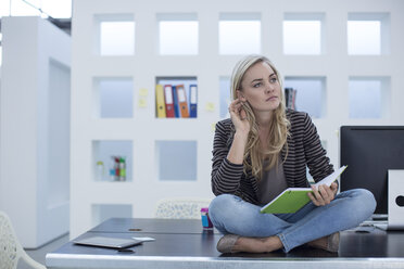 Creative office woman sitting on her desk with a day planner - ZEF003018