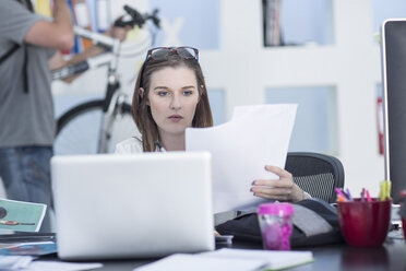 Creative office woman looking at documents - ZEF003058