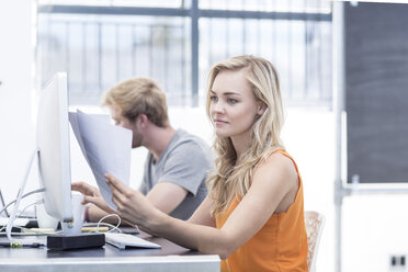 Creative office woman looking at papers - ZEF003072