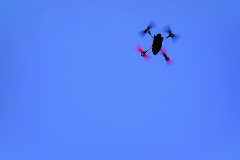 Fliegende Miniaturdrohne vor blauem Himmel - HOHF001270