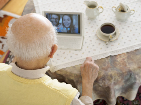 Videokonferenz zwischen Großvater und Enkelkindern über ein digitales Tablet, lizenzfreies Stockfoto