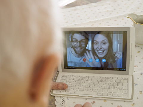Videokonferenz zwischen Großvater und Enkelkindern über ein digitales Tablet, lizenzfreies Stockfoto