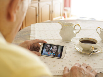 Videokonferenz des Großvaters mit den Enkelkindern über das Smartphone - LAF001328