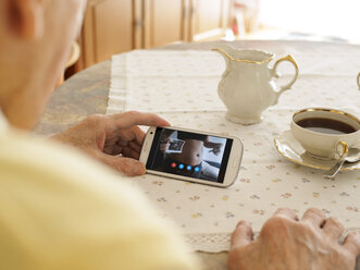 Großvater hält Videokonferenz mit schwangerer Enkelin über Smartphone - LAF001336