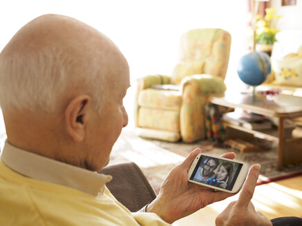 Videokonferenz des Großvaters mit den Enkelkindern über das Smartphone - LAF001332