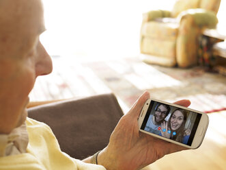 Videokonferenz des Großvaters mit den Enkelkindern über das Smartphone - LAF001333