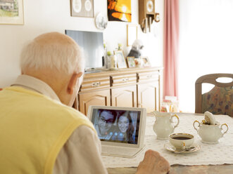 Videokonferenz zwischen Großvater und Enkelkindern über ein digitales Tablet - LAF001334