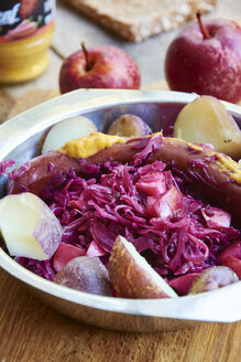 Rotkohl mit Äpfeln, serviert mit roten Pellkartoffeln und einer veganen Wurst - HAWF000665