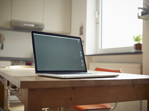 Laptop on kitchen table stock photo