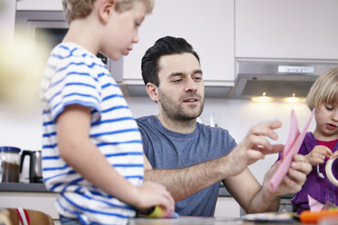 Vater bastelt mit Sohn und Tochter in der Küche - RHF000560