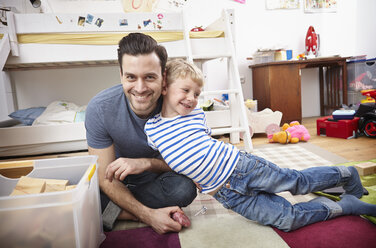 Vater und Sohn spielen zusammen im Kinderzimmer - RHF000609