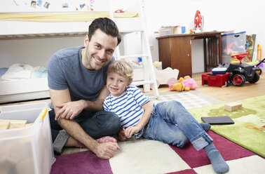 Father and son playing together in kid's room - RHF000610