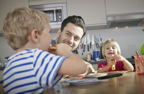 vater und Kinder beim Frühstück in der Küche, lizenzfreies Stockfoto