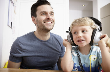 Father and son listening to music with headphones - RHF000634