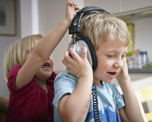 Bruder und Schwester hören Musik mit Kopfhörern - RHF000635
