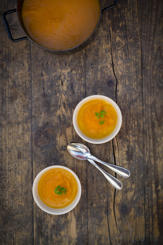 Kochtopf und Schalen mit Karottensuppe, lizenzfreies Stockfoto