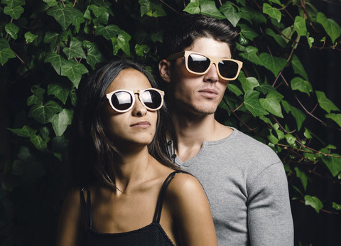 Porträt eines jungen Paares mit Holzsonnenbrille, lizenzfreies Stockfoto