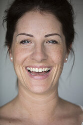 Portrait of laughing woman with freckles - SHKF000258