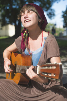 Weiblicher Straßenmusiker spielt Gitarre - DEGF000350
