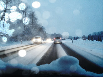 Germany, Upper Bavaria, Road traffic on snow covered road - LBF001064