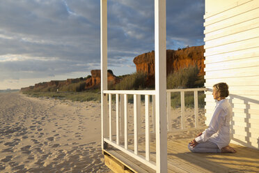 Portugal, Algarve, Frau macht Yoga-Übungen am Strandhaus bei Sonnenuntergang - MSF004499