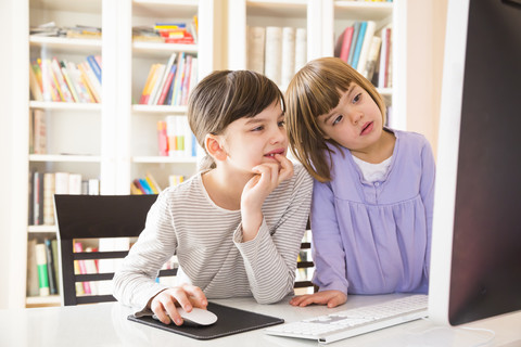 Zwei Schwestern verbringen gemeinsam Zeit am Computer, lizenzfreies Stockfoto