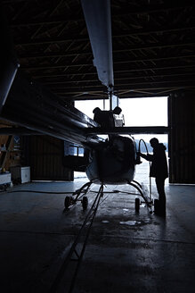 Mann bereitet Hubschrauber im Hangar vor - KDF000701