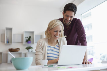 Glückliches Paar mit Laptop zu Hause - RBF002468