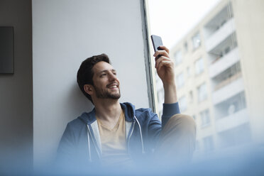 Ein lächelnder Mann macht ein Selfie mit seinem Smartphone - RBF002479