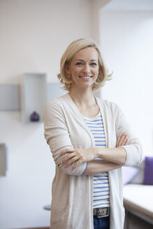 Portrait of smiling blond woman with crossed arms - RBF002508