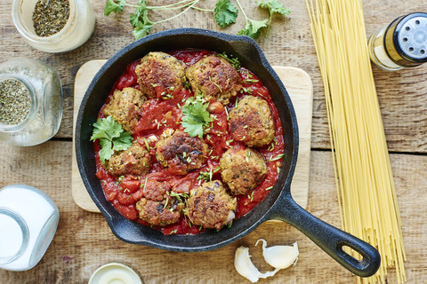 Vegan meatless balls in tomato sauce in a cast iron pan stock photo