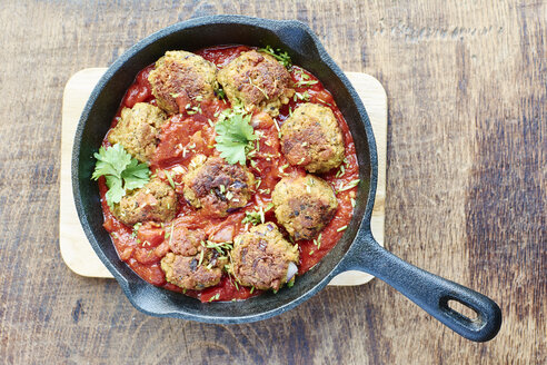 Vegan meatless balls in tomato sauce in a cast iron pan - HAWF000675