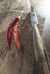 Sliced chili pepper and knife on wooden board - DEGF000354