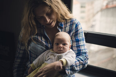 Porträt einer Mutter mit ihrem neugeborenen Baby am Fenster sitzend - RAEF000058