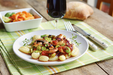 Fava-Bohnen und Champignons auf Gnocchi, serviert mit Salat, Rotwein und Brot - HAWF000679