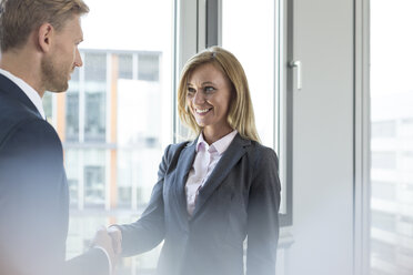 Businessman and businesswoman shaking hands - WESTF020873