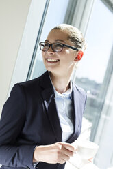 Young businesswoman holding cup - WESTF020954