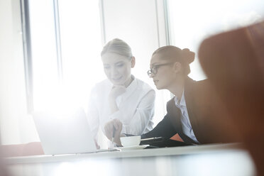 Zwei Geschäftsfrauen arbeiten zusammen und benutzen einen Laptop - WESTF020956