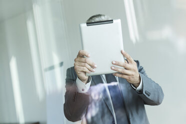 Geschäftsmann hält digitales Tablet, Gesicht verdeckt - WESTF020971