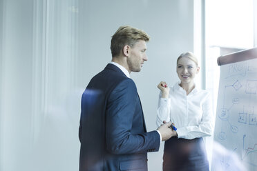 Geschäftsleute diskutieren am Flipchart über neue Strategien - WESTF020989