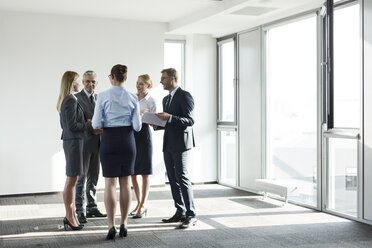 Business people standing in circle, talking - WESTF021019