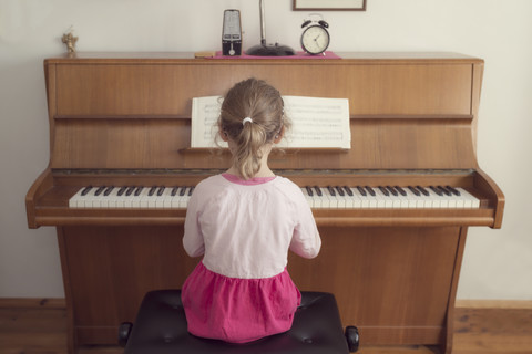 Kleines Mädchen spielt zu Hause Klavier, lizenzfreies Stockfoto